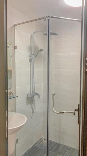 a shower with a glass door next to a sink at Yen’s House in Hanoi