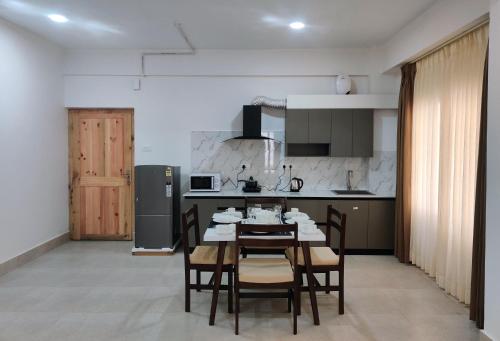 uma cozinha e sala de jantar com mesa e cadeiras em Happy apartment em Thimphu