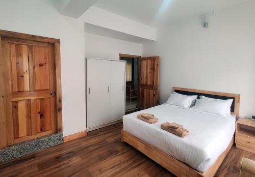 ein Schlafzimmer mit einem Bett mit zwei Handtüchern darauf in der Unterkunft Happy apartment in Thimphu