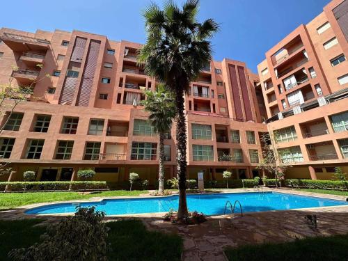 una palma di fronte a un grande edificio di Apartment Majorelle Garden With Pool a Marrakech