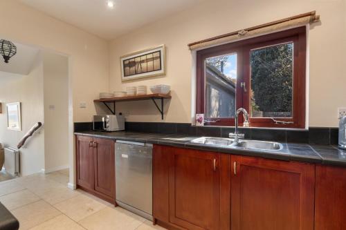 a kitchen with a sink and a window at Glendale Saundersfoot in Saundersfoot