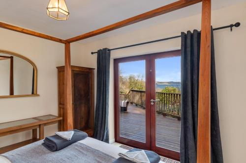 a bedroom with a bed and a sliding glass door at Glendale Saundersfoot in Saundersfoot