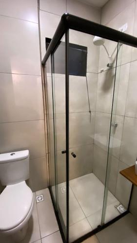 La salle de bains est pourvue de toilettes et d'une douche en verre. dans l'établissement Loft Santos dumont, à Mogi das Cruzes