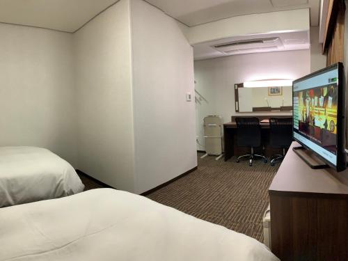 um quarto de hotel com duas camas e uma televisão de ecrã plano em Hotel Alpha-One Joetsu em Joetsu