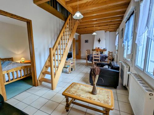 une chambre avec un escalier et un salon avec une table dans l'établissement Gîte Confortable en Pleine Nature avec Cheminée et Accès Direct aux Sentiers, Proche Gérardmer et Lac - FR-1-589-124, à Gérardmer