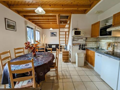 une cuisine et une salle à manger avec une table et des chaises dans l'établissement Gîte Confortable en Pleine Nature avec Cheminée et Accès Direct aux Sentiers, Proche Gérardmer et Lac - FR-1-589-124, à Gérardmer