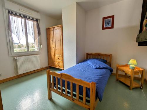 une chambre avec un lit, une fenêtre et une table dans l'établissement Gîte à Gérardmer - Proche lac et pistes, Chem cheminée, 2 chambres - FR-1-589-108, à Gérardmer
