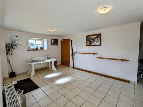 un salon avec une table et une fenêtre dans l'établissement Gîte à Gérardmer - Proche lac et pistes, Chem cheminée, 2 chambres - FR-1-589-108, à Gérardmer