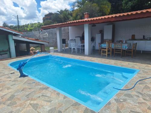 una piscina di fronte a una casa di Chácara Deh* a Bragança Paulista