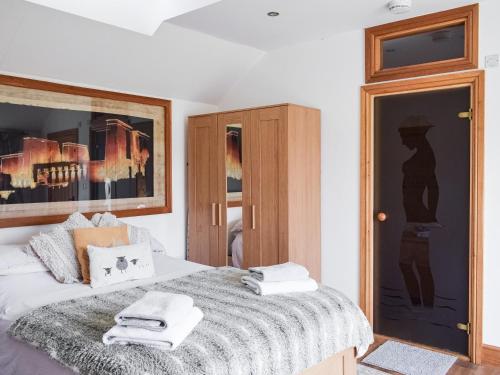 1 dormitorio con 1 cama con toallas en Norville Lodge, en Heathfield