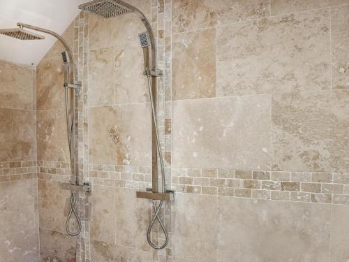 een badkamer met een douche en een stenen muur bij Norville Lodge in Heathfield