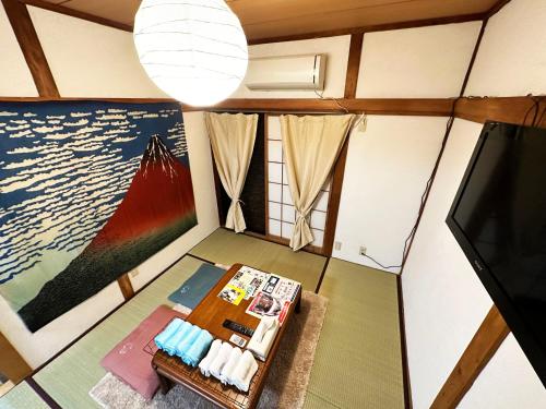 a living room with a tv and a table at 4 minute walk from the station,USJ33min KIX48min Namba10min, Convenience store, coin laundry, public bath, all 1 minute walk Kitakagaya INN OSAKA , 6 ppl, Near Namba to 10min,駅近徒歩4分一軒家貸切北加賀屋駅からなんば駅まで10分 in Osaka