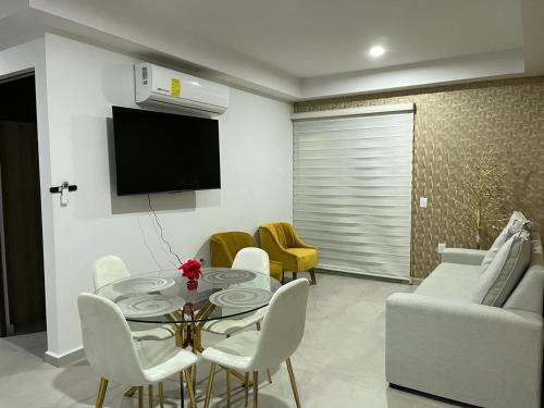 ein Wohnzimmer mit einem Tisch und Stühlen sowie einem TV in der Unterkunft Departamento en mazatlan bluue Lagoons in Mazatlán
