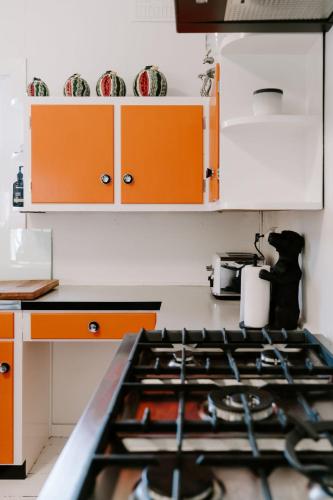 a kitchen with orange cabinets and a stove at The Endless Summer- 30 seconds walk to the beach in Culburra Beach