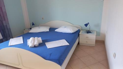 - une chambre avec un lit bleu et des serviettes dans l'établissement Apartments by the sea Tisno, Murter - 13588, à Tisno