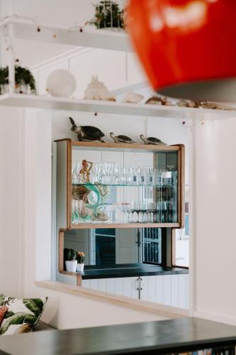 a shelf with cups and glasses on it at The Endless Summer- 30 seconds walk to the beach in Culburra Beach
