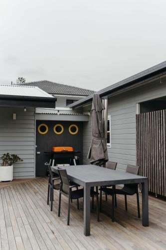 a patio with a table and chairs on a deck at The Endless Summer- 30 seconds walk to the beach in Culburra Beach