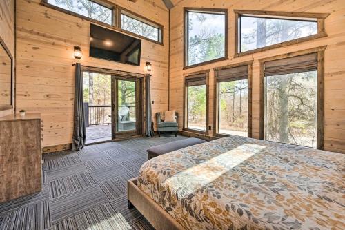 1 dormitorio con 1 cama en una habitación con ventanas en Family Getaway 10-Bed Cabin w Hot tub & Firepit, en Broken Bow