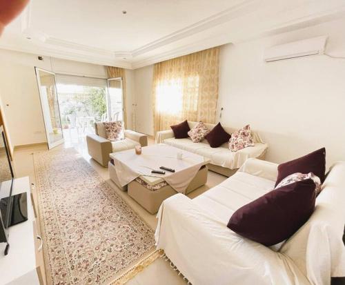 a living room with white couches and a rug at vibrant bright house of La Marsa in La Marsa
