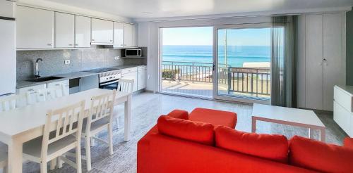 uma cozinha e sala de estar com vista para o oceano em AG Casa Vilamar en primera linea de playa Razo em Razo da Costa