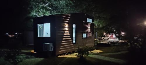 a small cabin in the middle of a yard at night at Tiny house Alto bosque in Pucón
