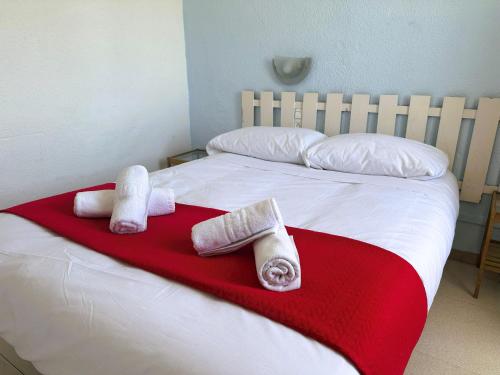 ein Bett mit drei Handtüchern auf einer roten Decke in der Unterkunft Barraca Suites in Valencia