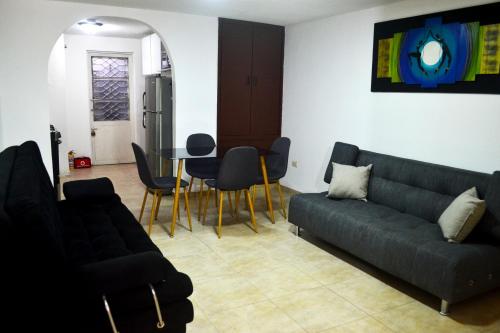uma sala de estar com um sofá, uma mesa e cadeiras em Bonito aparta estudio central em Bogotá