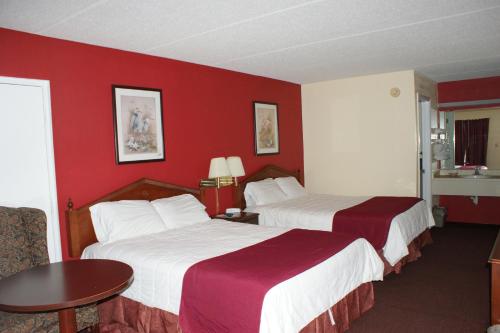 2 camas en una habitación de hotel con paredes rojas en The Patriot Inn, en Register