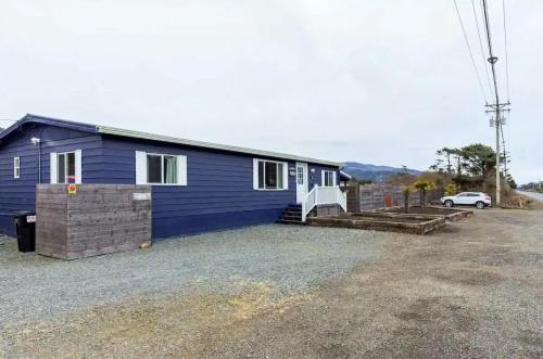 a blue house with a car parked in front of it at Tiki Escape w/ Amazing Mountain and Marsh Backdrop in Rockaway Beach