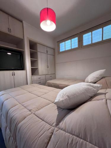a bedroom with two beds and a flat screen tv at Departamento PH 4 ambientes La perla a 5 cuadras de playa in Mar del Plata