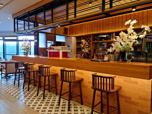 een bar met houten krukken in een restaurant bij Alvea Hotel and Residences in Baguio