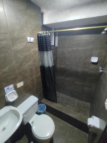 a bathroom with a toilet and a shower at HOSTAL WALDORF.EC in Baños