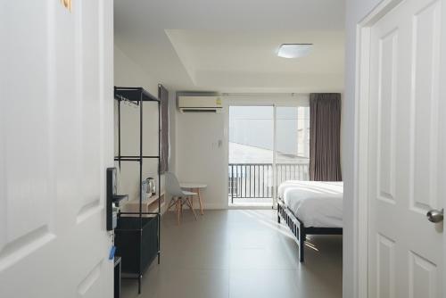a bedroom with a bed and a view of a balcony at Mitr Inn Mrt Samyot Station - The Grand Palace in Bangkok