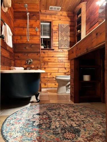 a wooden bathroom with a tub and a toilet at The Cedar House - Huntsville Cultural District in Huntsville