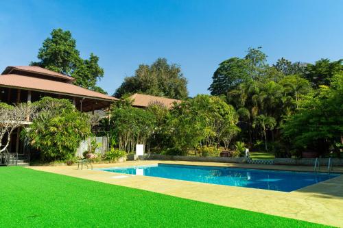 a backyard with a swimming pool and green grass at The Hub Erawan Resort in Chongsadao