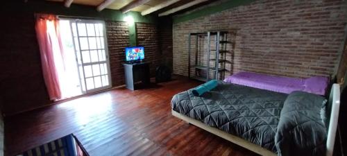 a bedroom with a bed and a brick wall at Depto AGUSTIN in Malargüe
