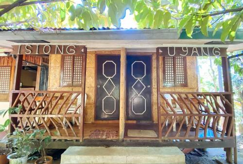 ein kleines Holzgebäude mit einer Tür mit Fenstern in der Unterkunft RedDoorz @ Hilarion's Farm Majayjay, Laguna in Majayjay