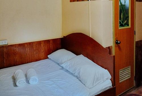 ein Bett mit zwei Kissen und zwei Handtüchern darauf in der Unterkunft RedDoorz @ Hilarion's Farm Majayjay, Laguna in Majayjay