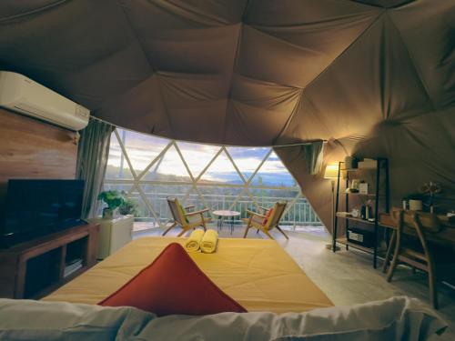 a bedroom with a tent with a table and chairs at Moondock Luxury Camp in Munduk