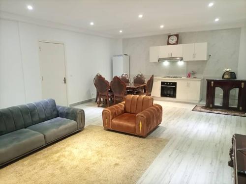 a living room with a couch and chairs and a kitchen at Appartement bord de mer in Pointe-Noire