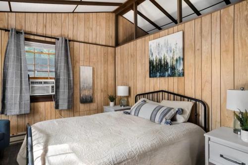 1 dormitorio con cama y ventana en Secluded Cabin Hot Tub, Huge Deck, Fire Pit, WiFi, en Hedgesville