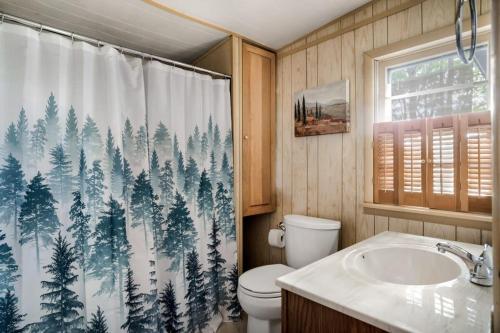 baño con aseo y cortina de ducha con árboles en Secluded Cabin Hot Tub, Huge Deck, Fire Pit, WiFi, en Hedgesville