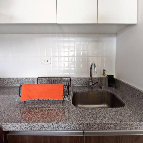 a kitchen sink with an orange towel on it at Apartamento con increíble vista al mar in Lima