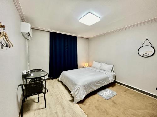 um quarto com uma cama e uma mesa em Royal motel em Goseong