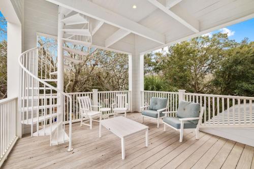 a white porch with chairs and a table at Serenity Now - Private Pool,5 Bikes,Gulf Views, Steps to the Beach and Seaside! in Seagrove Beach