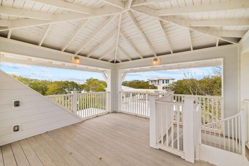 a white screened porch with white railings and a ceiling at Serenity Now - Private Pool,5 Bikes,Gulf Views, Steps to the Beach and Seaside! in Seagrove Beach