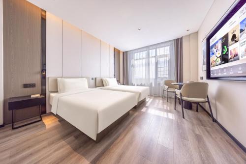 梅州的住宿－梅州梅县柏丽广场亚朵酒店，酒店客房设有两张床和一台平面电视。