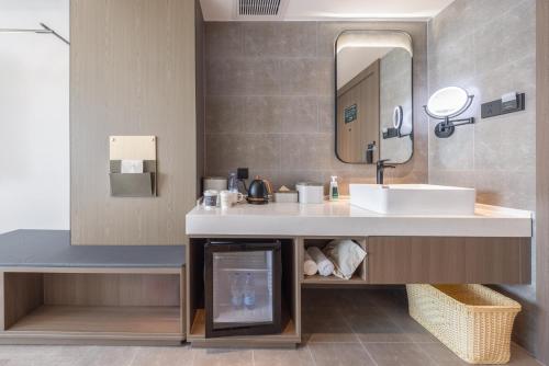 y baño con lavabo y espejo. en Atour Hotel Meizhou Meixian Baili Plaza, en Meizhou