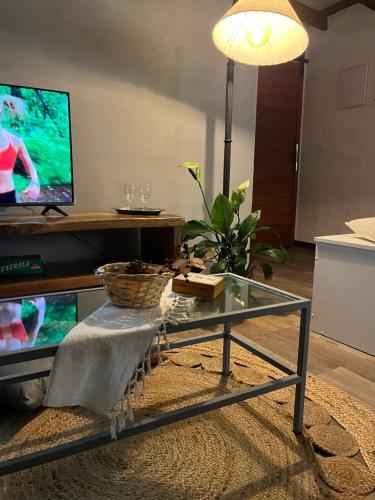 a living room with a glass coffee table and a tv at La Luna, casa mágica en sierras! in Villa Serrana