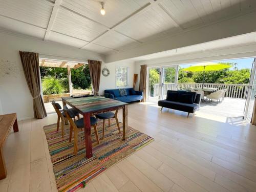 a living room with a wooden table and chairs at Oneroa Village Oasis - Stay Waiheke in Blackpool